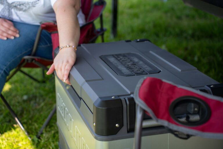 Opening a portable fridge at a campsite